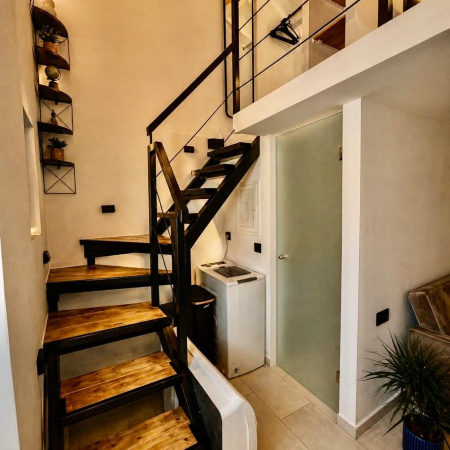 Wood and steel staircase up to the loft bedroom