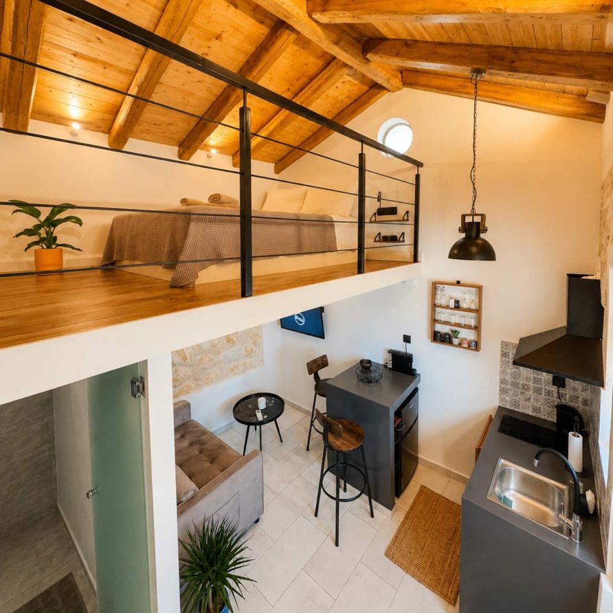 Open-plan studio with the loft bedroom above the kitchen and living area