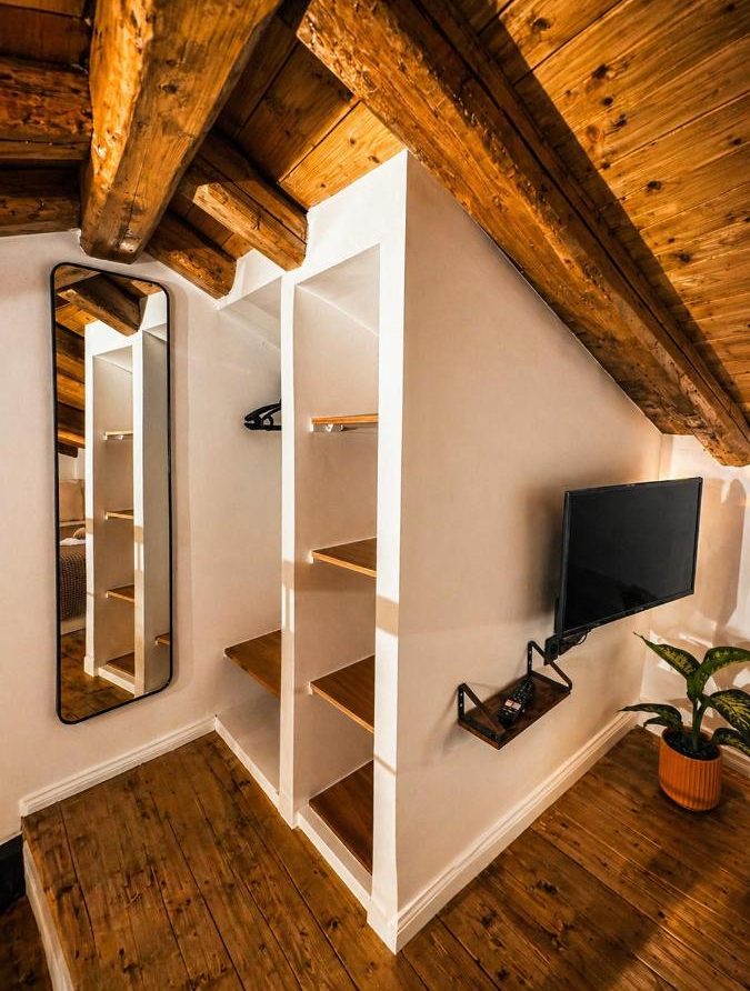 Living area with wooden ceiling, TV and shelves